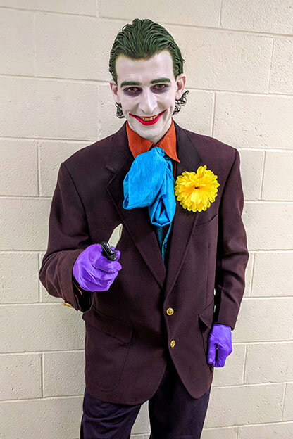 The Joker grins and brandishes a knife.