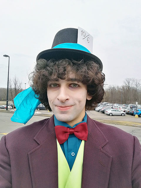The Mad Hatter stands outside.