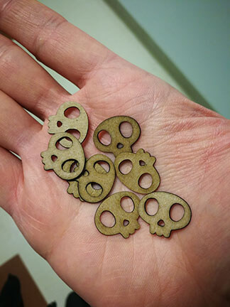 A handful of cut cardboard skull pins.