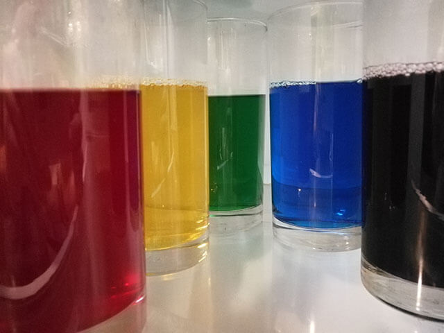 Glasses with the colored Jell-O setting in the refrigerator.