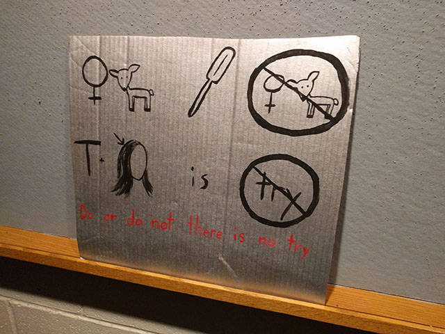 The example rebus puzzle shows a female symbol next to a dear, an oar, a female symbol next to a deer inside a no symbol, T plus a head with an arrow pointing to the hair, the word is, and the word try inside a no symbol.  Doe oar no doe, T hair is no try.  Do or do not, there is no try.  The solution is written at the bottom of the panel.