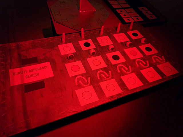 Under a red light, the second row of the android parts appears readable, and the red playing cards appear blank.